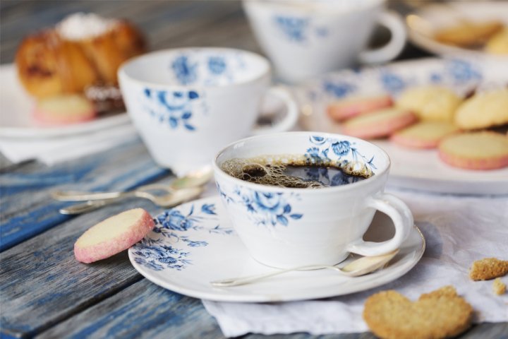 En kopp kaffe och några kakor på ett bord